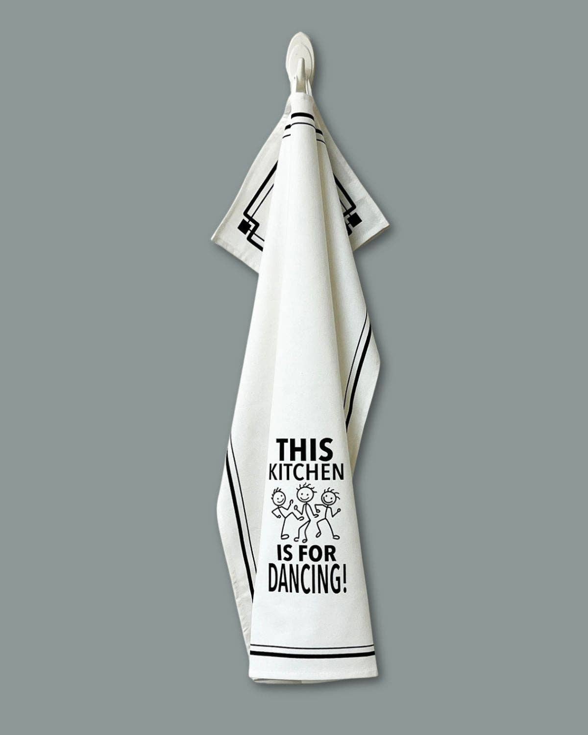 White kitchen towel with black text and graphics on a gray background