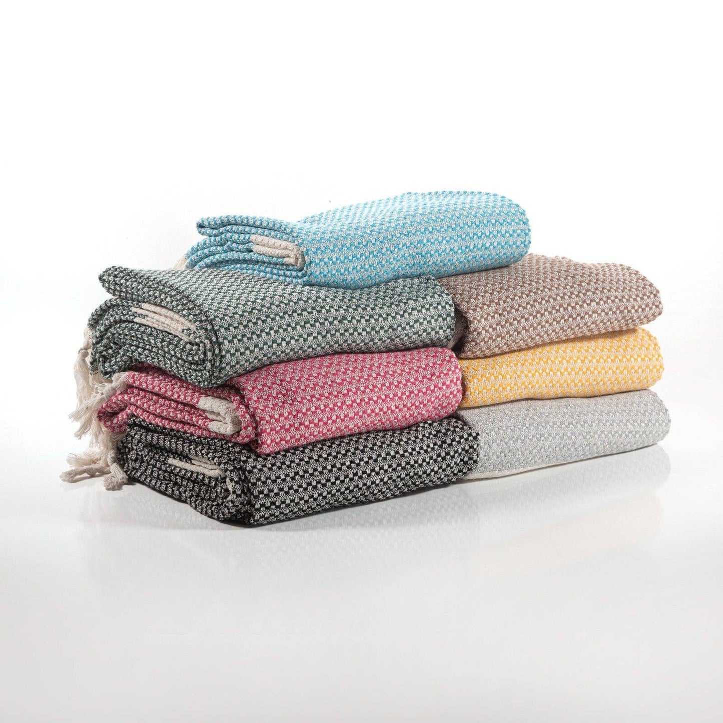 Stack of folded towels in various colors on a white background