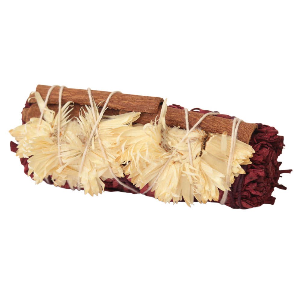 Bouquet of dried flowers and cinnamon sticks tied together on a white background