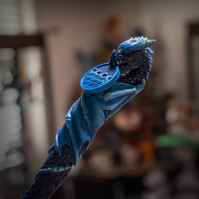 Blue dragon-shaped keychain with a rope on a blurred background