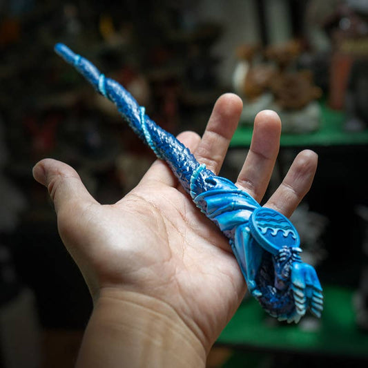 Hand holding a blue dragon-shaped pen with a blurred background