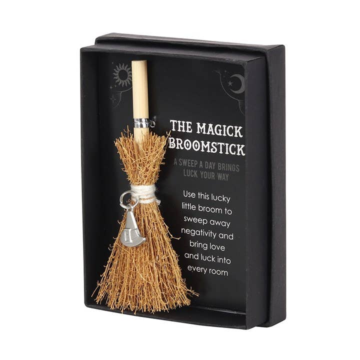 Magick broomstick with decorative box on a white background
