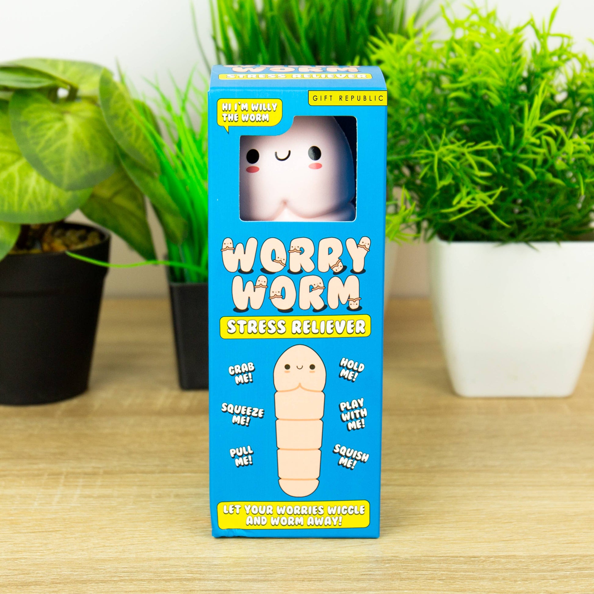 Worry Worm stress reliever packaging on a wooden surface with plants in the background