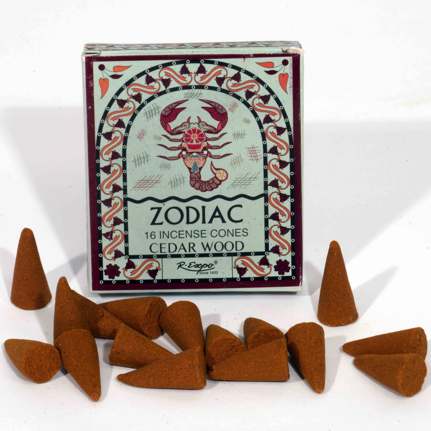 Box of zodiac incense cones with a scorpion design, surrounded by cedar wood incense cones on a white background.