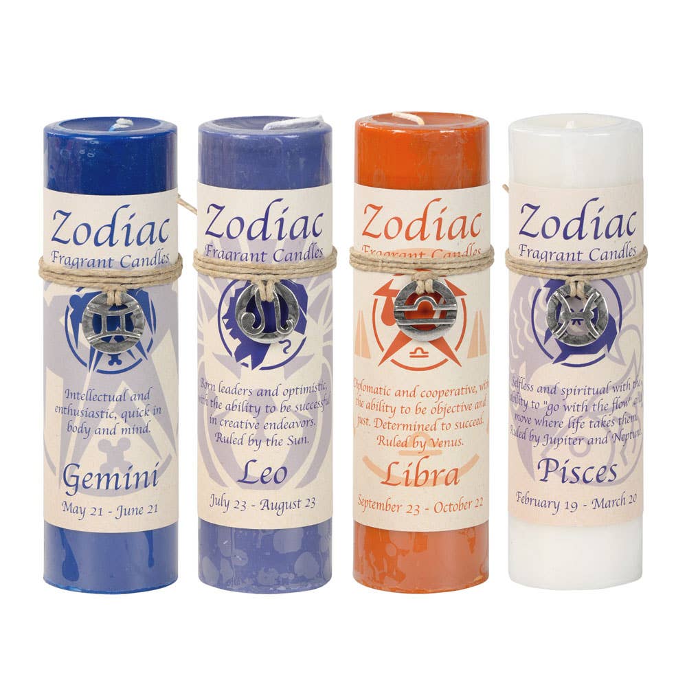 Four zodiac-themed candles in their packaging on a white background