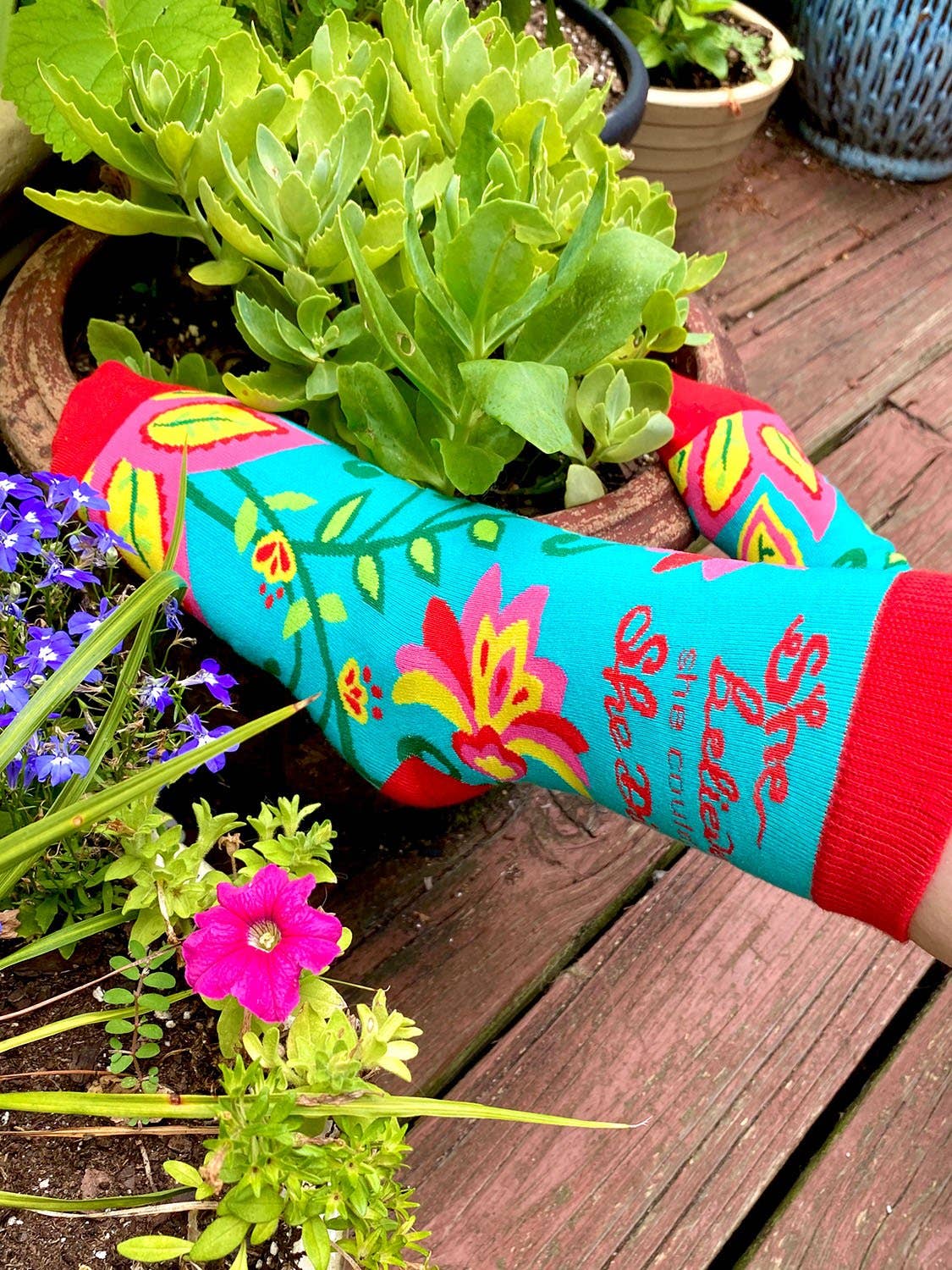 Colorful garden-themed arm sleeve with plants and flowers on a wooden surface